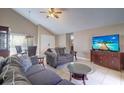 Cozy living room with gray sofas, a large TV, and ample natural light at 4451 Tidal Pond Rd, New Port Richey, FL 34652