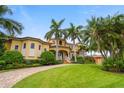Beautiful two-story home with a curved driveway and palm trees at 1363 Oceanview Dr, Tierra Verde, FL 33715