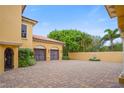 Elegant courtyard with paver driveway, fountain, and two-car garage at 1363 Oceanview Dr, Tierra Verde, FL 33715