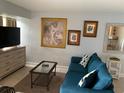 Living room with teal sofa, coffee table, and a large piece of wall art at 3315 58Th S Ave # 218, St Petersburg, FL 33712