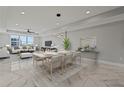 Elegant dining room with modern chandelier and marble floors at 211 Dolphin Pt # 201, Clearwater, FL 33767