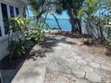 Landscaped backyard with a walkway leading to the waterfront at 1425 Corey S Way, South Pasadena, FL 33707