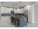 Modern kitchen with white cabinetry, large island, and high-end appliances at 211 Dolphin Pt # 302, Clearwater, FL 33767