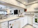 Bright kitchen with white cabinets, granite countertops, and stainless steel appliances at 960 Starkey Rd # 2303, Largo, FL 33771