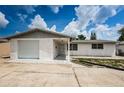 White brick ranch home with a single car garage and a spacious driveway at 3423 Eisenhower Dr, Holiday, FL 34691