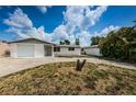 Front view of a ranch-style house with white brick facade and a curved driveway at 3423 Eisenhower Dr, Holiday, FL 34691