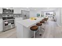 Modern kitchen with stainless steel appliances and an island with seating at 8 Glencoe Pl # 208, Dunedin, FL 34698