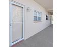 Building hallway with light walls and a white door at 8 Glencoe Pl # 208, Dunedin, FL 34698