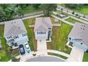 An aerial view of a two-story home with a gray roof, fenced yard, and a driveway with two cars at 10913 Trailing Vine Dr, Tampa, FL 33610