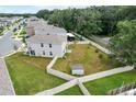 Aerial view of a spacious backyard with a white fence, green grass, and a small shed at 10913 Trailing Vine Dr, Tampa, FL 33610