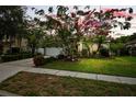 House with blooming tree and landscaped yard at dusk at 4931 Ridgemoor Cir, Palm Harbor, FL 34685