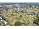 Aerial view of the community near a golf course, featuring ponds, trees, and lush greenery at 12300 Vonn Rd # 3204, Largo, FL 33774