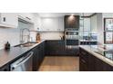 Modern kitchen with dark wood cabinets, stainless steel appliances, and a stylish backsplash at 1848 Shore S Dr # 501, South Pasadena, FL 33707