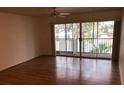 Living room with hardwood floors and sliding glass doors to balcony at 9720 Indian Key Trl # 117, Seminole, FL 33776
