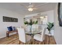 Dining area with glass table, four chairs and hardwood floors at 9415 Blind Pass Rd # 1103, St Pete Beach, FL 33706