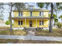 Two-story yellow house with a large front porch and stone walkway at 553 Division St, Tarpon Springs, FL 34689