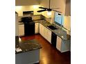 Bright kitchen featuring granite countertops and ample cabinetry at 2101 Sunset Point Rd # 1001, Clearwater, FL 33765