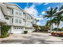 Charming townhouse with a two-car garage, lush tropical landscaping, and a sunny front facade at 213 46Th Ave, St Pete Beach, FL 33706