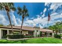 Community clubhouse with landscaping and flag at 2525 Royal Pines Cir # 26-A, Clearwater, FL 33763