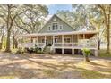 A charming house with a large front porch, set amongst mature trees at 3136 Neff Lake Rd, Brooksville, FL 34602