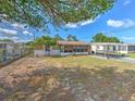 Tan single story house with carport, screened porch and landscaped yard at 4718 Trafford Rd, Holiday, FL 34690