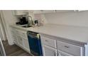 Kitchen boasts white cabinets, white quartz countertops, and stainless steel appliances at 1153 Tamarac Dr, Holiday, FL 34690