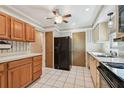 Kitchen features wood cabinets, black appliances, and tile floor at 11200 102Nd Ave # 51, Seminole, FL 33778