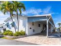 White mobile home with covered patio and landscaping at 18675 Us Highway 19 N # 377, Clearwater, FL 33764