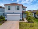 Two-story home with gray siding, teal door, and landscaping at 9509 Lamine Way, Parrish, FL 34219