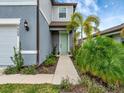 Home's entrance with teal door and walkway at 9509 Lamine Way, Parrish, FL 34219