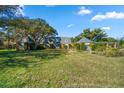 Brick home with unique outbuildings, mature trees, and green lawn at 2850 Sunstream Ln, Clearwater, FL 33759