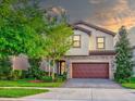 Two story house with brown garage door and landscaping at 12874 Burns Dr, Odessa, FL 33556