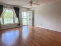 Bright living room with wood floors, natural light from large windows, and a ceiling fan at 2256 Philippine Dr # 46, Clearwater, FL 33763