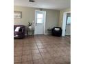Cozy living room with a neutral color scheme, tile flooring, and a comfortable seating arrangement by the doorway at 2305 N Tampania Ave, Tampa, FL 33607