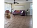 Inviting living room features tile flooring, a cozy sofa, and ample natural light streaming through sheer curtains at 2305 N Tampania Ave, Tampa, FL 33607