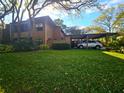 Home with a covered parking area and lush green lawn at 103 Cypress Pond Rd # 103, Palm Harbor, FL 34683