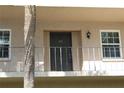 Condo building exterior door entrance with a balcony and palm tree at 8693 Bardmoor Blvd # 207B, Seminole, FL 33777