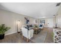 Living room with comfy seating, wood-look floors, and large windows at 101 Lake Ne Ave # 125, Largo, FL 33771