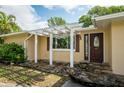 Charming house featuring a pergola, stone pathway, and updated front door at 2045 Golf View Dr, Dunedin, FL 34698