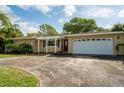 Single story home with attached garage and pergola at 2045 Golf View Dr, Dunedin, FL 34698