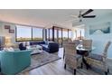Open-concept living area with a dining set, comfortable seating, and bright natural light from large windows at 6219 Palma Del Mar S Blvd # 602, St Petersburg, FL 33715