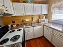 Bright kitchen featuring white cabinets, wood flooring, and modern appliances at 2625 State Road 590 # 1523, Clearwater, FL 33759