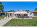 Adorable one-story home with a striped awning and a white picket fence at 247 93Rd N Ave, St Petersburg, FL 33702