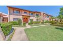 A beautiful condo with a well-manicured lawn, trimmed hedges, palms, and a cozy porch at 9543 86Th Ave # 9543, Seminole, FL 33777