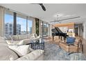Bright living room with a piano, sleek furniture, and large windows offering city views at 1000 Water St # 1703, Tampa, FL 33602