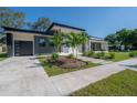 Modern home with gray and white exterior, landscaping, and a paved driveway at 4511 24Th S Ave, St Petersburg, FL 33711