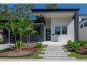 Modern house with gray and white exterior, landscaping, and walkway at 4511 24Th S Ave, St Petersburg, FL 33711