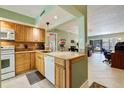 Bright kitchen featuring wood cabinets, granite countertops, and views of the dining and living areas at 6365 Bahia Del Mar Blvd # 105, St Petersburg, FL 33715