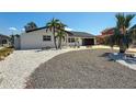 Beautiful single-story home with a modern garage door, well-maintained driveway, and charming landscaping at 240 N Julia Cir, St Pete Beach, FL 33706