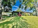 Ranch style home with lush landscaping and a spacious lawn at 1223 Queen Anne Dr # C, Palm Harbor, FL 34684